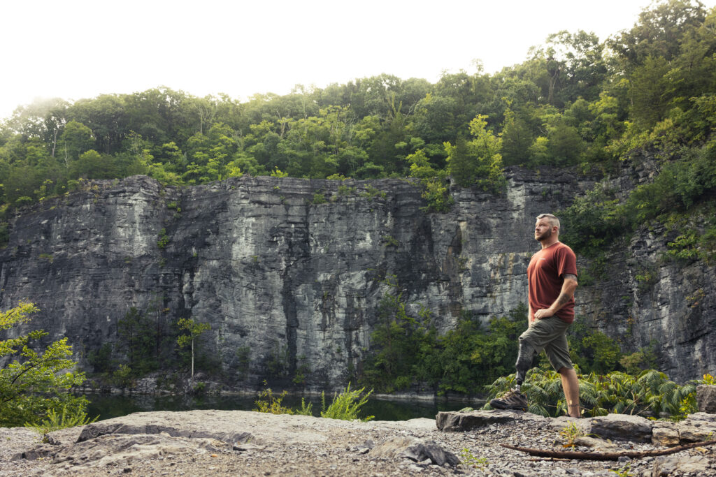 Traverse AV user standing on rocky terrain beside a lake